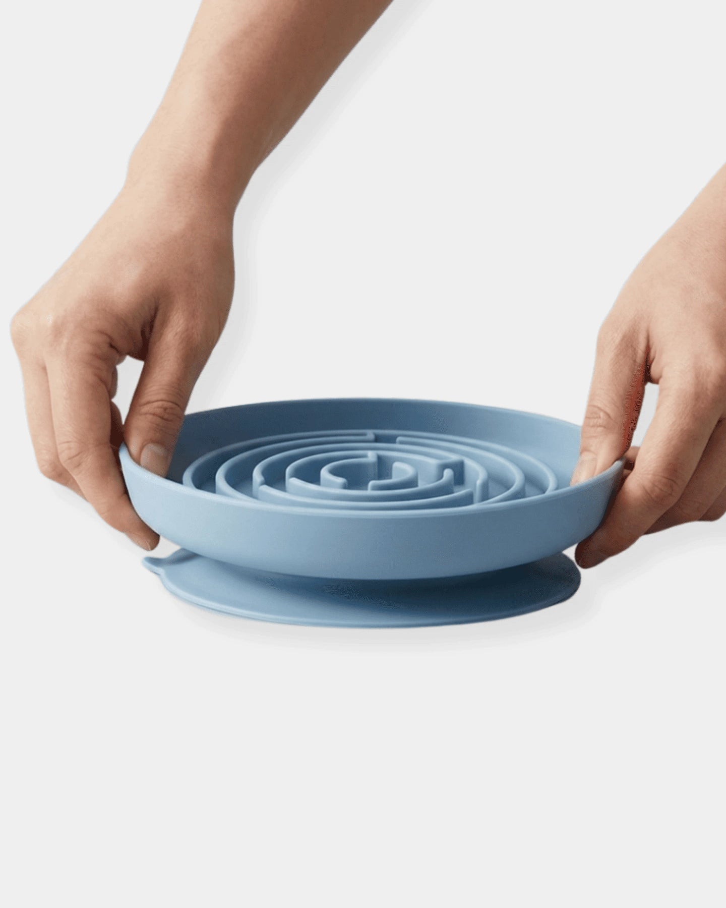Blue silicone mat with spiral design held by hands on a white background