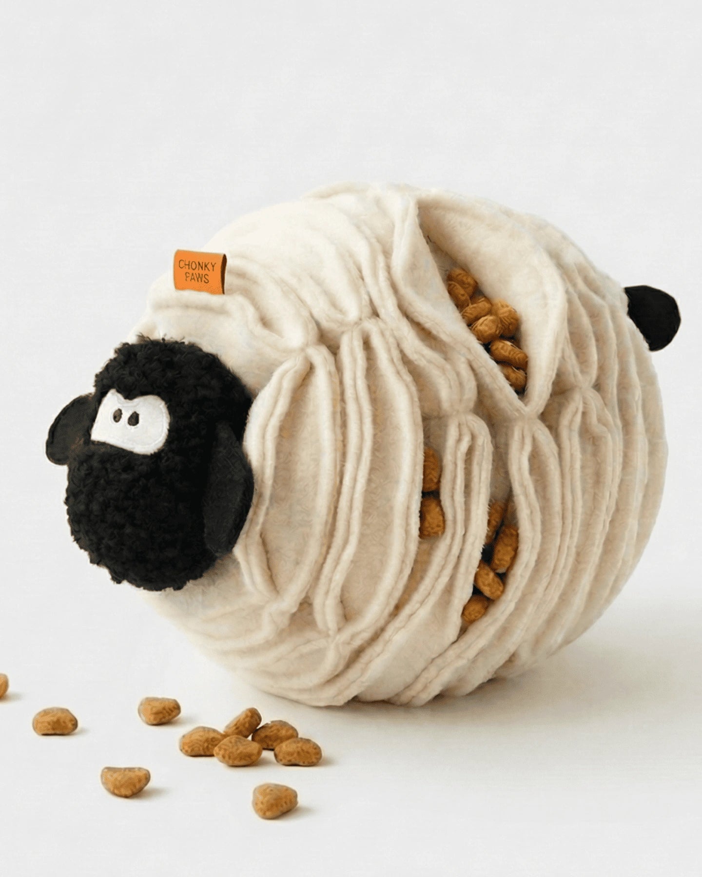 Sheep-shaped pet toy with treats on a white background