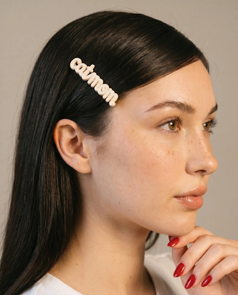 Woman wearing a decorative cat mom clip with a neutral background